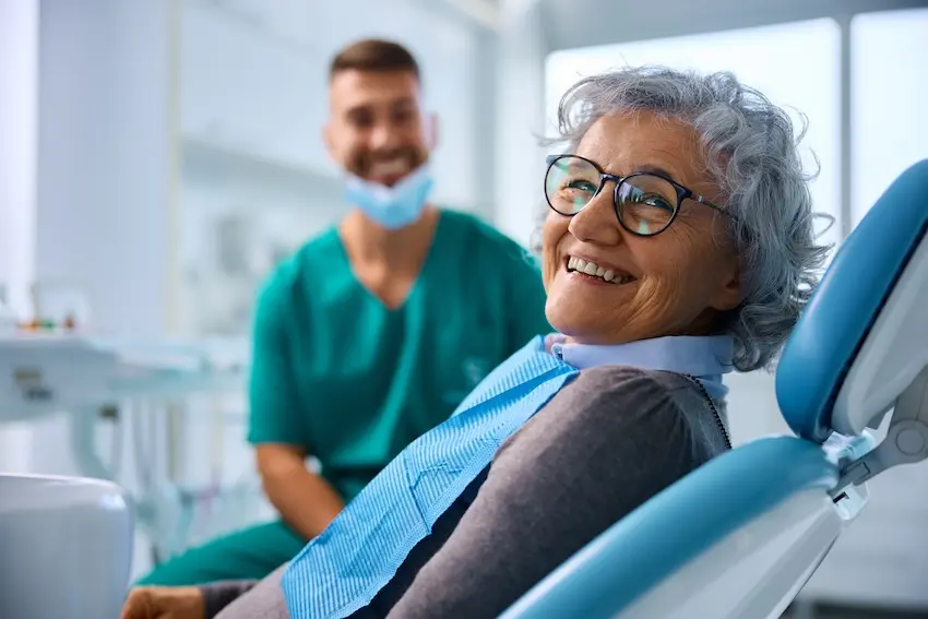 Middle-aged woman smiling confidently after dental implant treatment at a Virginia Beach dental office