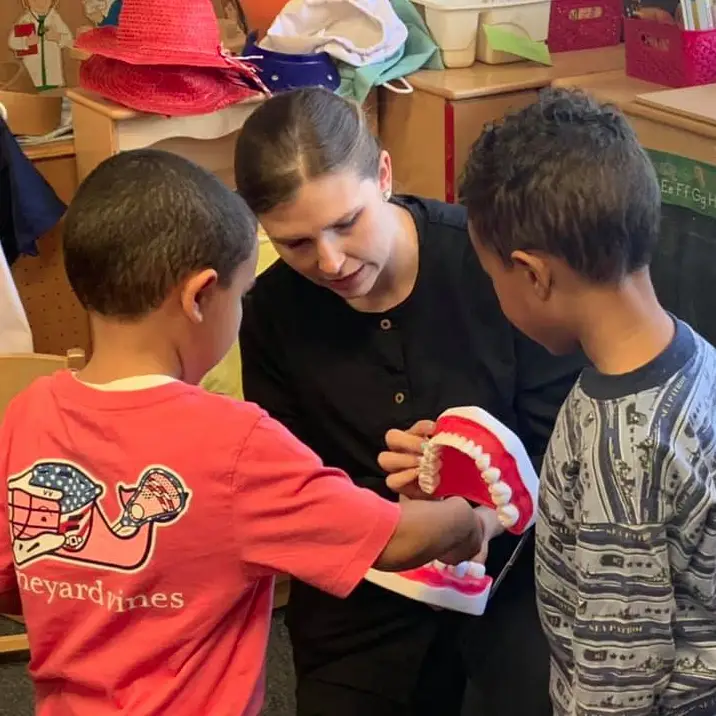 2 children looking at model of teeth